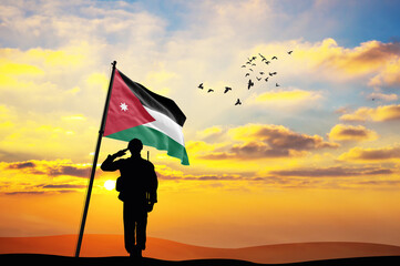 Silhouette of a soldier with the Jordan flag stands against the background of a sunset or sunrise. Concept of national holidays. Commemoration Day.