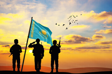 Silhouettes of soldiers with the Kazakhstan flag stand against the background of a sunset or sunrise. Concept of national holidays. Commemoration Day.