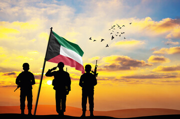 Silhouettes of soldiers with the Kuwait flag stand against the background of a sunset or sunrise. Concept of national holidays. Commemoration Day.