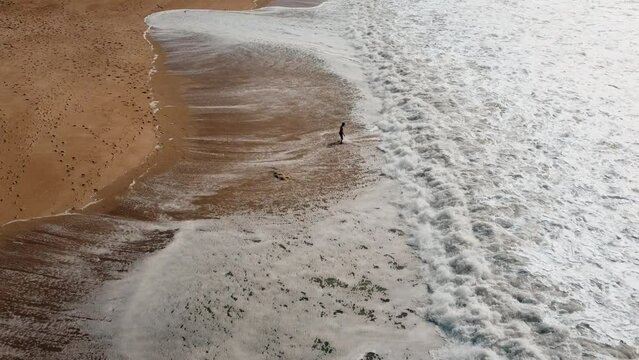 Aerial view showing person at shore of Atlantic Iceman enjoying foam of waves during Sunny day
