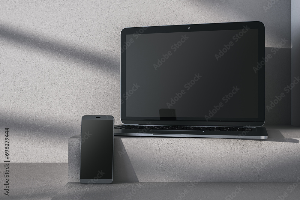 Aufkleber close up of empty laptop and cellphone on gray desk. concrete wall background and pedestal or podium