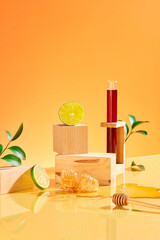 Wooden blocks are artistically arranged with fresh lemons, green leaves and honey on an orange...