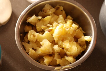 Boiled Mashed potatoes in a steel bowl with selective focus on marble floor