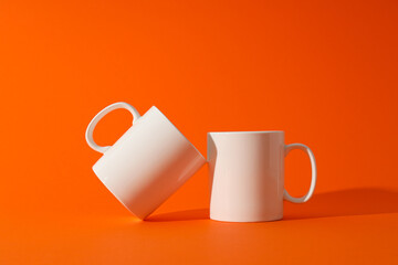 White beautiful cups on an orange background