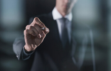 Left hand writing with marker on transparent board on black background