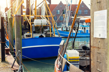 Traditional old german fishing cutter boats moored Neuharlingersiel harbor Wadden sea East Frisia Northern Germany. Commercial fish crab shrimp trawler beam trawl nets North Sea small port city