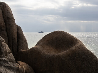 A picture of the brown rocks with a sea view in the background.