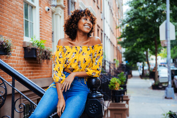 Pretty african american woman wearing fashionable stylish clothing in New York - Portrait of pretty adult black female strolling in the city - obrazy, fototapety, plakaty