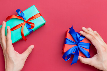 celebration atmosphere. hands hold two gifts in a colored wrapper. new year concept