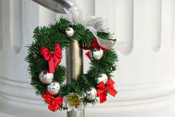 The Christmas Wreath hanging on fence.