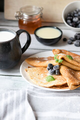 Breakfast: fresh pancakes with berries. On a wooden background. Morning