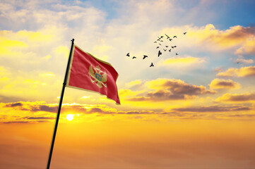 Waving flag of Montenegro against the background of a sunset or sunrise. Montenegro flag for Independence Day. The symbol of the state on wavy fabric.