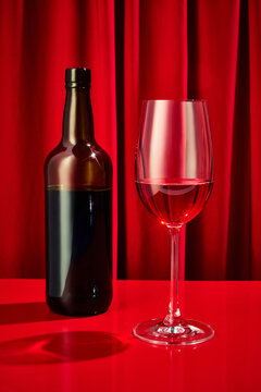 Close up photo of sweet red, pink seasoned wine served in high glass classy and bottle of wine on bar counter at restaurant. Concept of night life, party time, holidays, Valentines Day, celebration