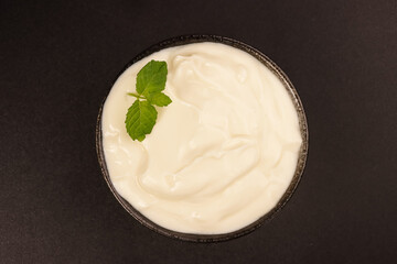 Yogurt in a Black Bowl Isolated on Black Background