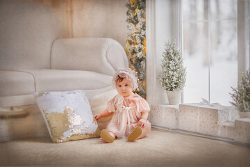 Obraz na płótnie Canvas A small beautiful girl in a vintage dress sits by a large panoramic window. Baby close-up. The girl smiles. New Year. Christmas. Girl in a vintage hat. Doll. Portrait of a baby. Winter. Lights in the 