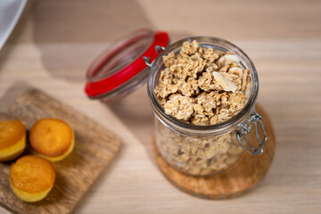 muesli spilled from a glass jar on a wooden table,A jar of home made granola