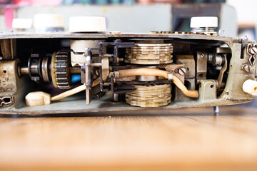 Repairman master is testing old disassembles sewing machine in workshop repairing it sitting at...