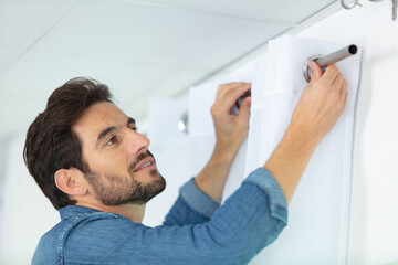 man installing window blinds in a house