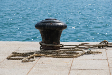 Stahl-Poller mit Seilen in einem Hafen (harbour - mooring bollard) / Poller mit Tauwerk - dahinter...