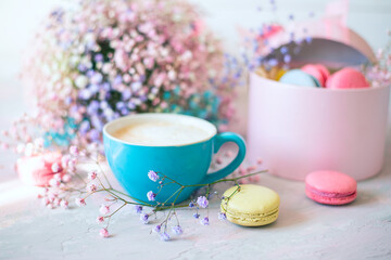 Obraz na płótnie Canvas sweet colorful macaroons, cute colorful flowers and a cup of coffee with milk on a delicate light pink background. Atmosphere of celebration and romance 