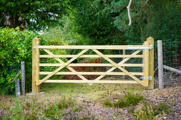 Wooden gate in front of woodland in the countryside 