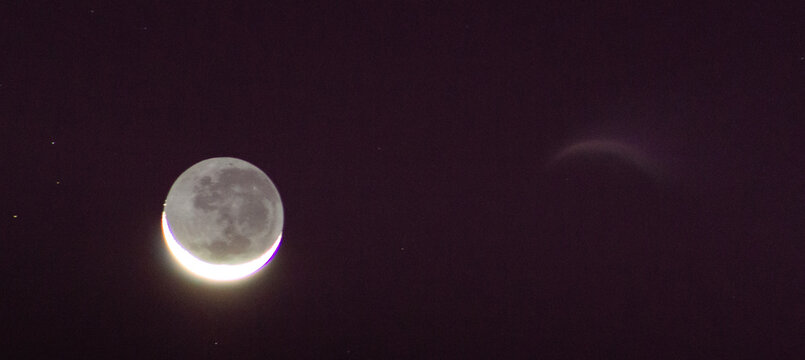 Waning crescent moon against a purple and black night sky.