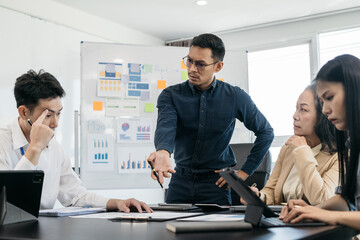 Group of Young Asian business team creative businesspeople coworker in office. Meeting Presentation for analysis graph company financial. People Work in Business Office.