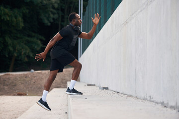 Side view. Sportive black man is running, morning routine