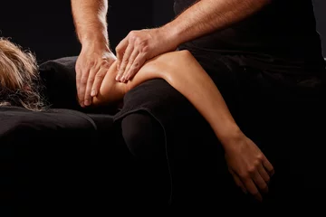 Papier Peint Lavable Spa handsome male masseur giving massage to girl on black background, concept of therapeutic relaxing massage