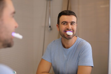 Man whitening  his teeth at home 