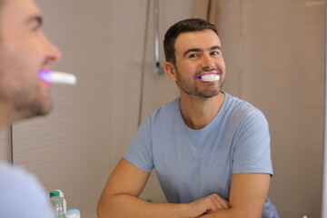 Fototapeta premium Man whitening his teeth at home 