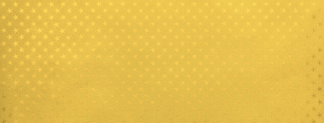 Golden and yellow background from metal foil paper with pattern of sparkling stars closeup.