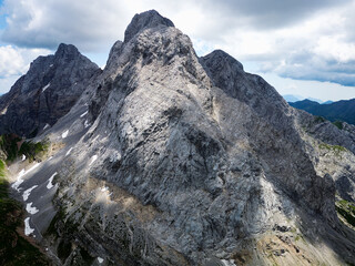 Aerial view of mount Coglians in the border of Italy and Austria. Cloudy day with some sun opening. Vibrant colors. Beautiful destinations for hikers.