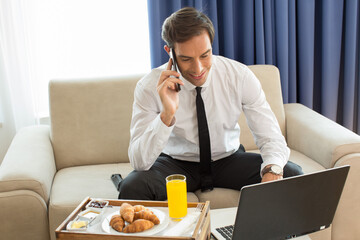 Businessman talking on the mobile phone in his hotel room