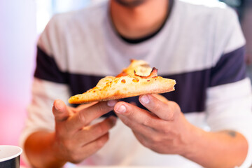 Mysterious figure savors steaming pizza.