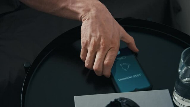 High angle stab shot of alarm going off on charging phone with inscription Good Morning and waking up man in morning at home or hotel