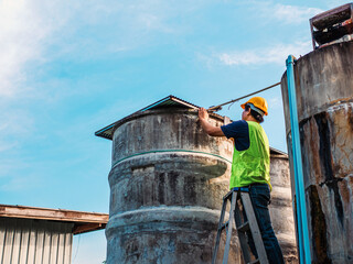 engineer controlling the quality of water Stand on the risky stairs at high places operating...