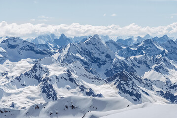 Snow-covered winter mountains of the Caucasus on a sunny day. Panoramic view from the ski slope of Elbrus, Kabardino-Balkaria, Russia - 696354869
