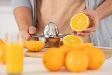 closeup on man making orange juice
