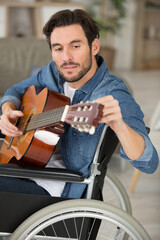 disabled man playing guitar at home