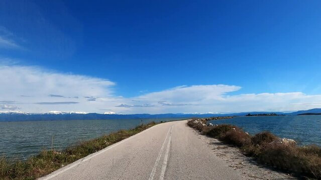 Car view of road in Koronisia iconic road in the middle of the sea in Greece
