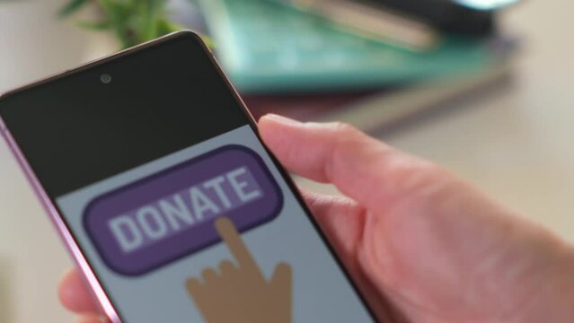 Female hand holding and using phone and text Donate on phone