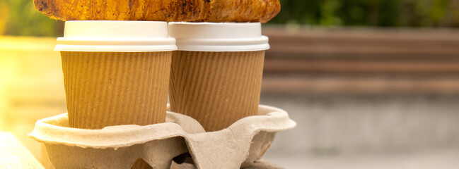 Fresh baked chocolate croissant on Two paper cups with lid for tea to go. Breakfast Coffee take...