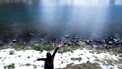 Happy woman enjoying Czarny Staw pod Rysamy or Black Pond lake near the Morskie Oko Snowy Mountain...