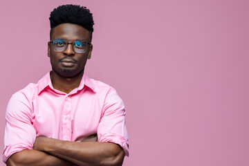 portrait of a man. a man in a pink shirt and glasses folds his arms on his chest, looks at the camera. portrait concept