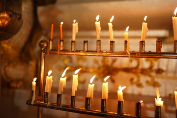 Lit candles on an ornate stand, offering a warm, tranquil glow for spiritual or religious observance