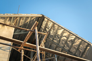 Obraz premium The under construction residential house with pre-casting concrete structure and wooden material scaffold frame. building industrial construction site, selective focus.