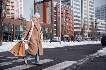 Photo of adorable pretty woman wear beige coat crossing road purchase new year presents outside...