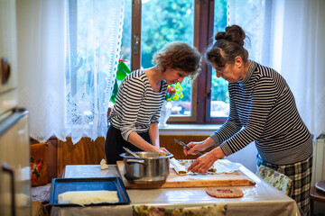 Senior and Mature Women Preparing Apple Strudel in the Domestic Kitchen