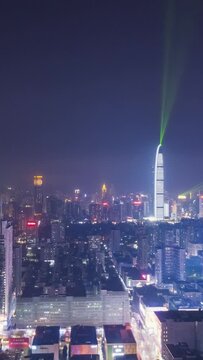 Shenzhen City at Night. Futian and Luohu District. China. Aerial Hyper Lapse, Time Lapse. Drone Flies Sideways and Upwards. Vertical Video